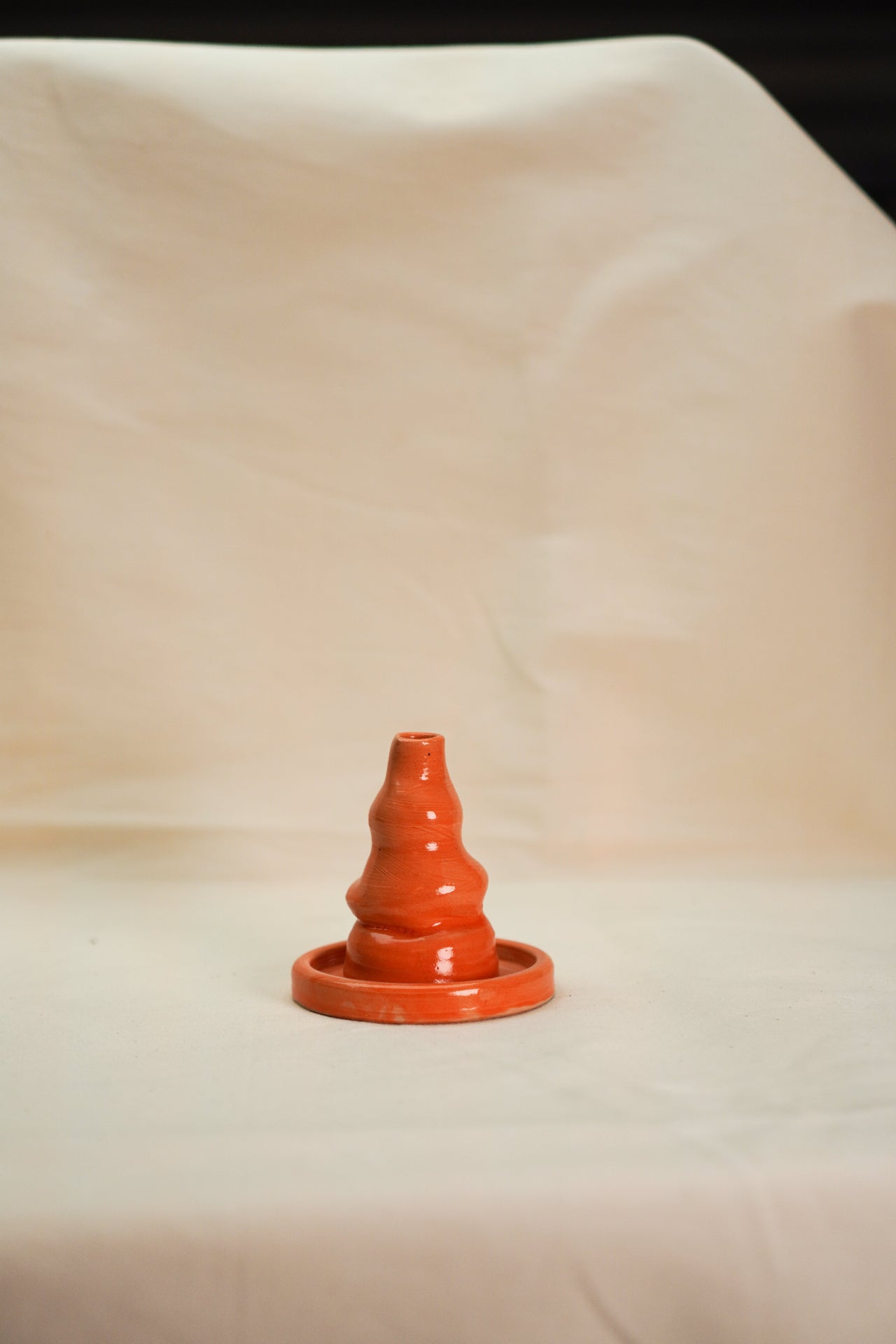 Pomarańczowy kominek na kadzidło stożkowe w formie wulkanu.