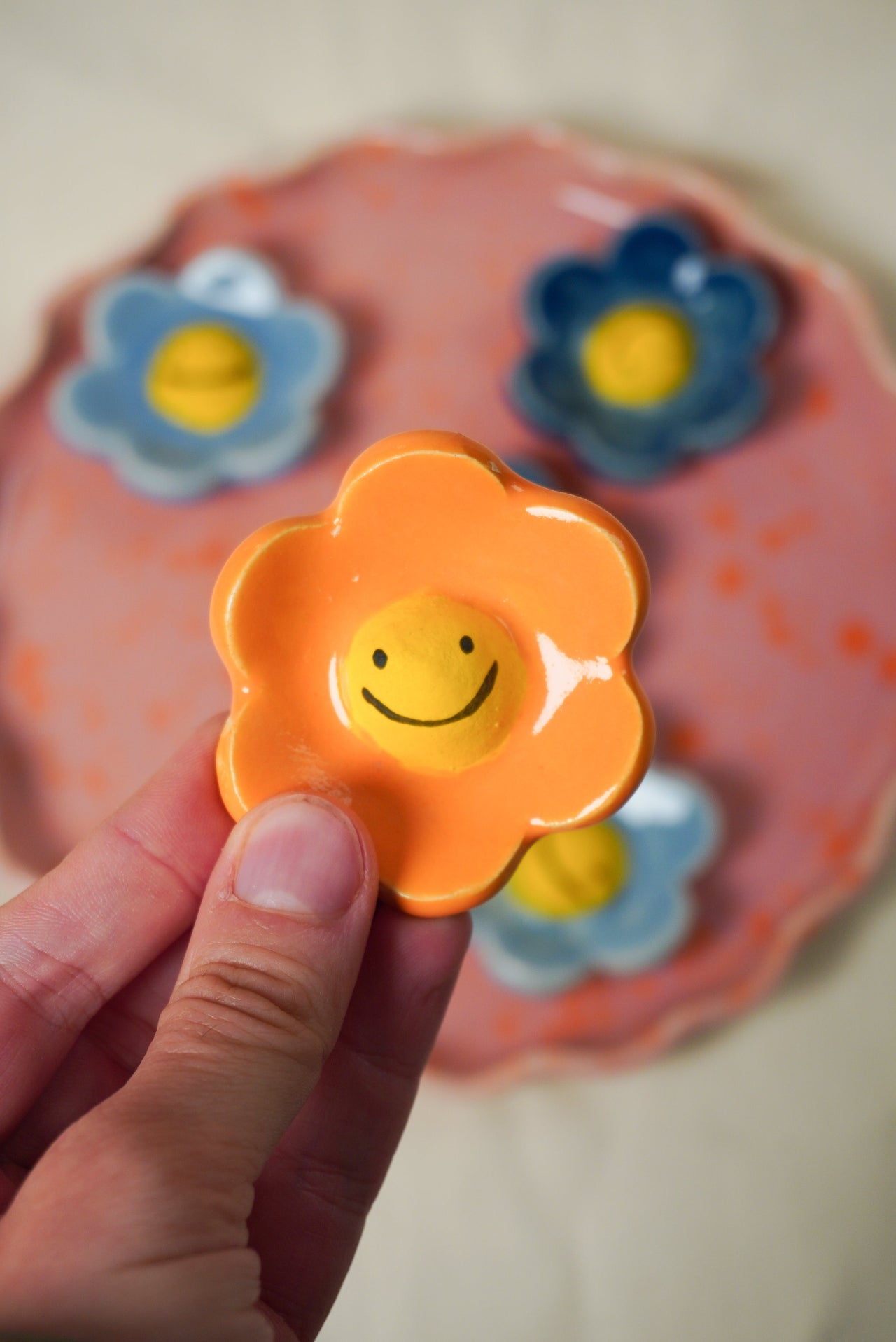 Pomarańczowy magnes kwiatek z uśmiechem ceramiczny 